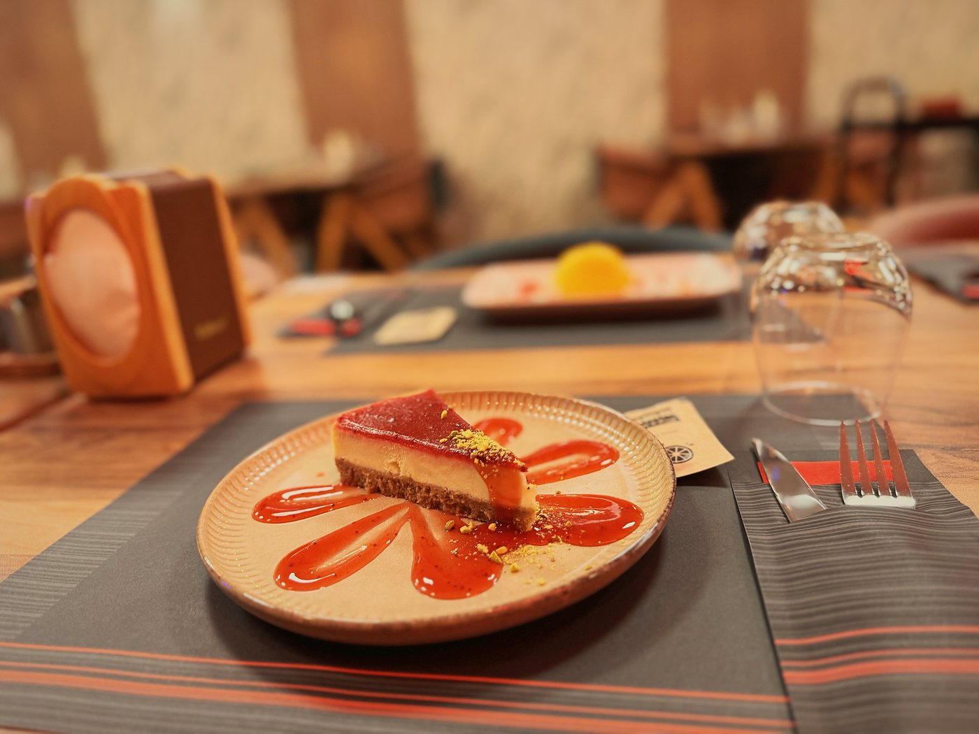Cheesecake met frambozencoulis op een geribbeld bord